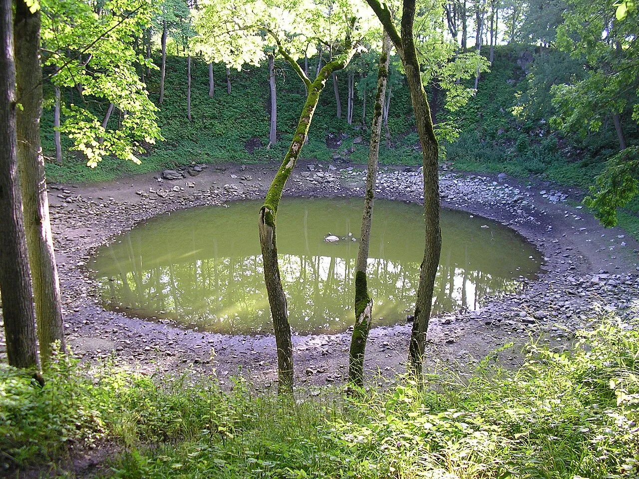 The main crater is nearly circular. When the water level is low, rocks can be seen penetrating the surface in the middle