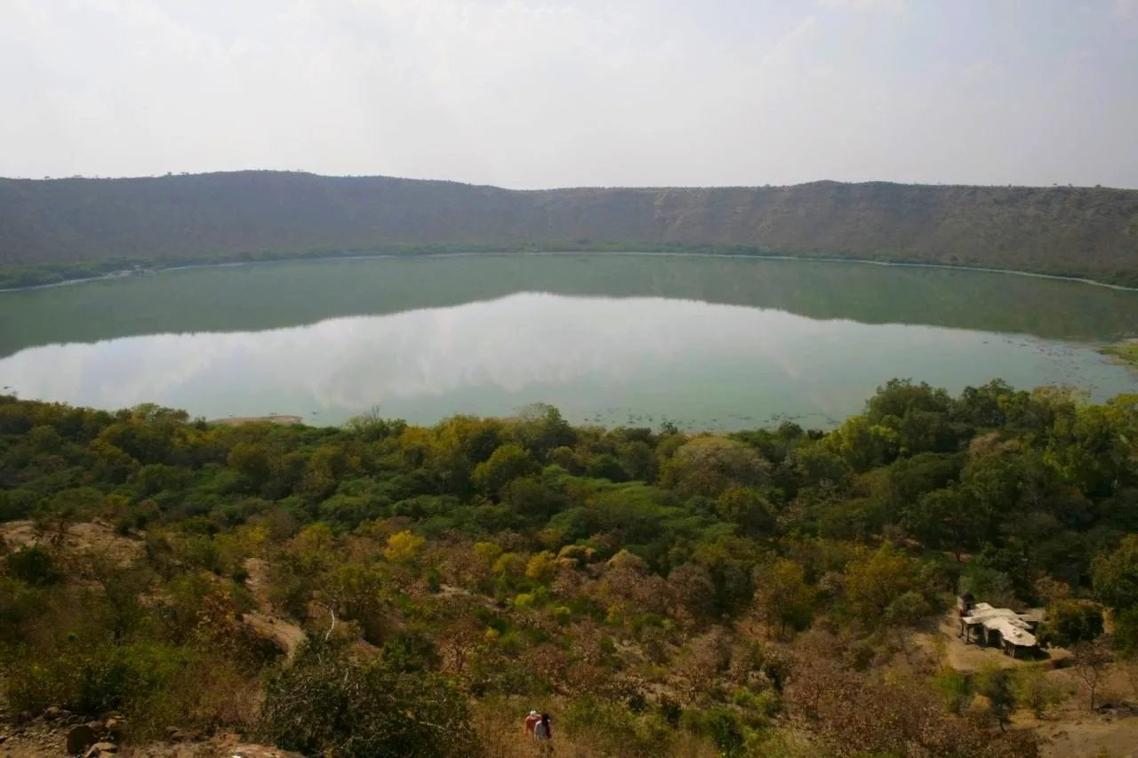 View of the crater from the edge. A temple is visible in the forest underneath.
