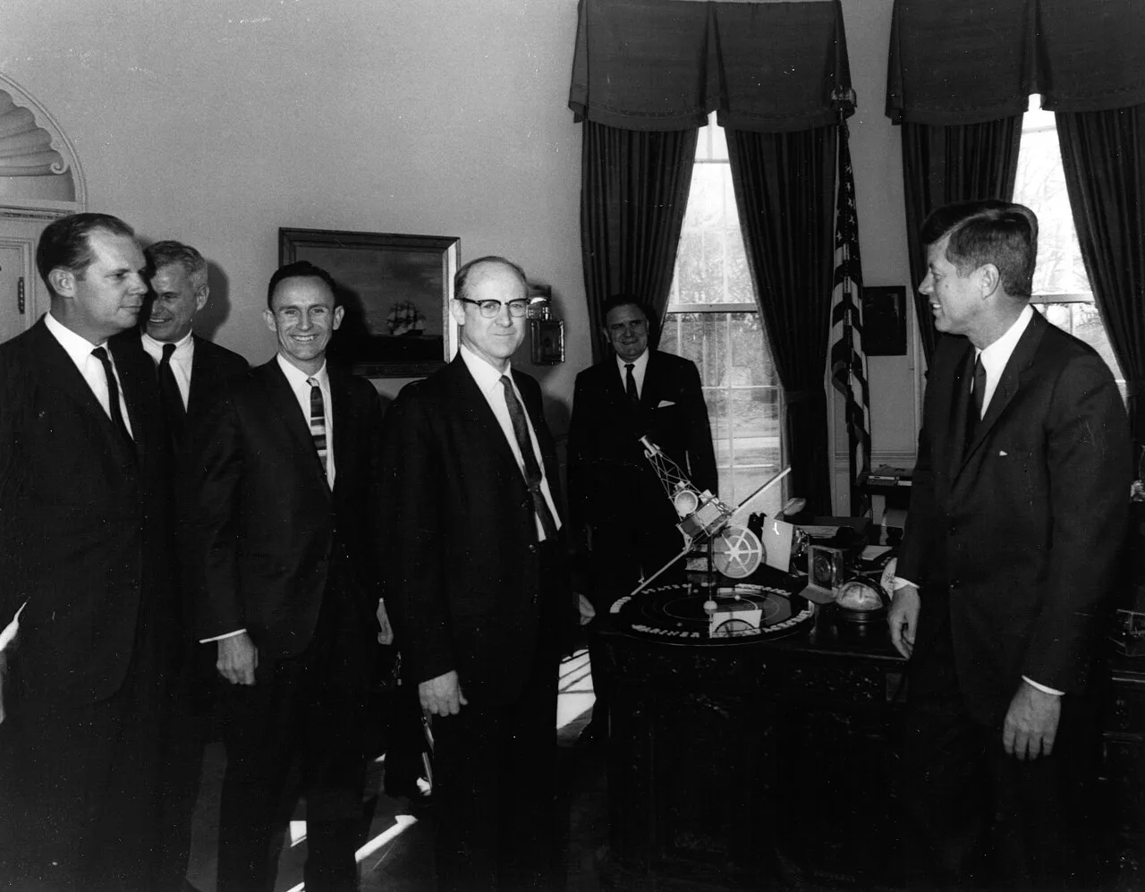 President Kennedy is shown a model of Mariner 2 during a meeting with NASA officials after the successful completion of