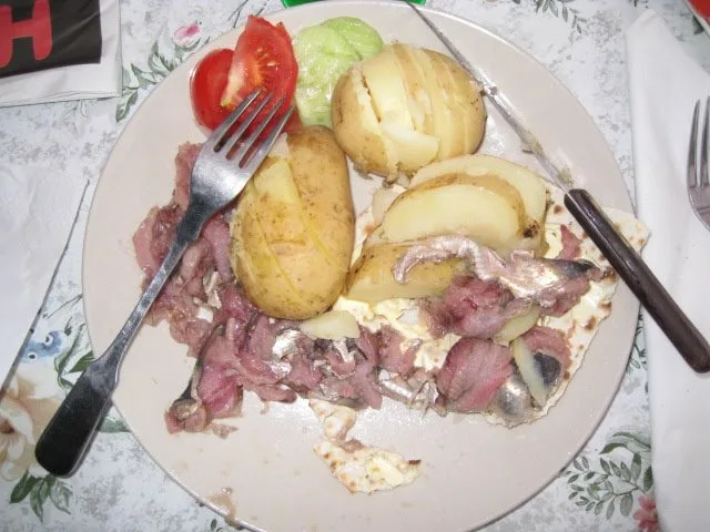 Surströmming served on tunnbröd (a Swedish flatbread) with boiled potatoes and vegetables