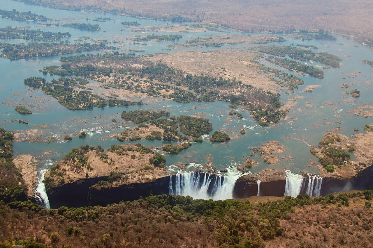 Aerial view of Victoria Falls on the Zambezi River, showing the full width of the falls and the braided river channels a