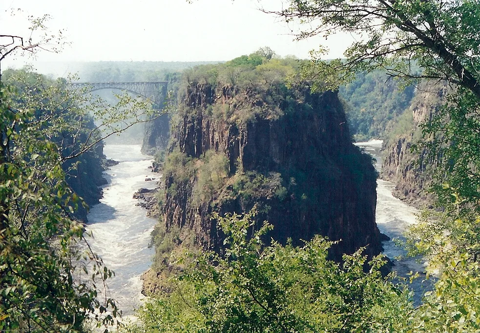 Victoria Falls' Second Gorge (with bridge) and Third Gorge (right). The peninsular cliffs are in Zambia, the outer cliff